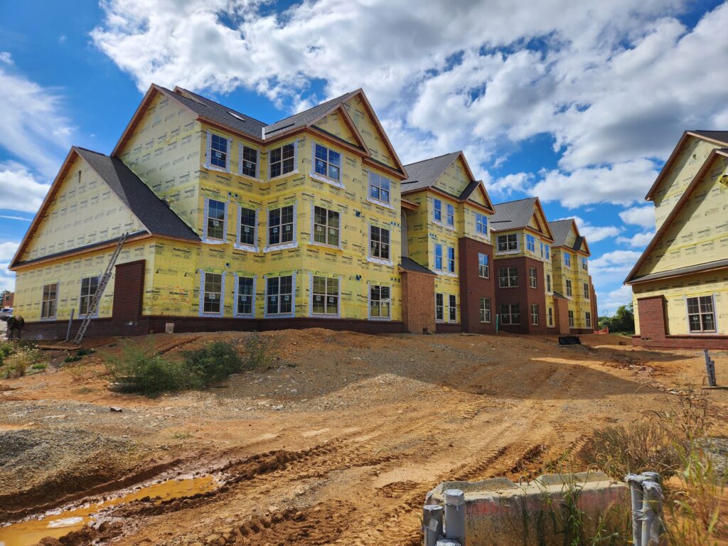 Unfinished houses in a planned neighborhood with yellow weather wrap.